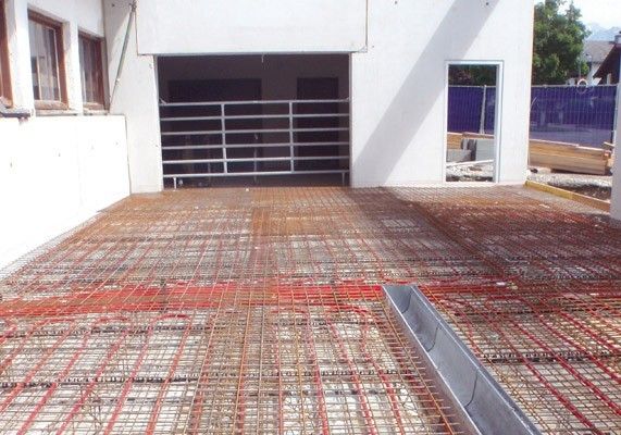 Bodenplatte mit installierter Fußbodenheizung in einer Baustelle.